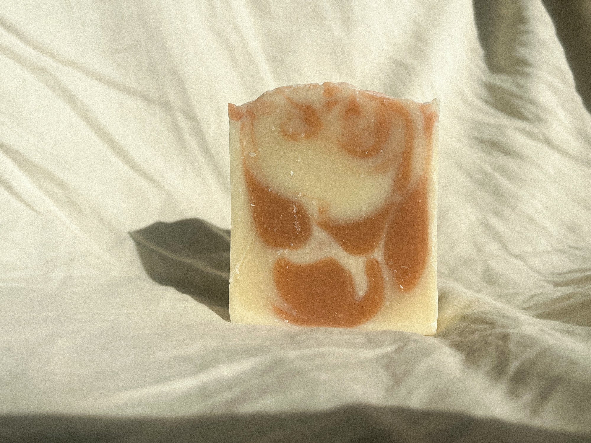 regeneratively raised orange and patchouli scented tallow soap handcrafted for all ages and sensitive skin, all natural no synthetics, naturally colored with plants and clays 